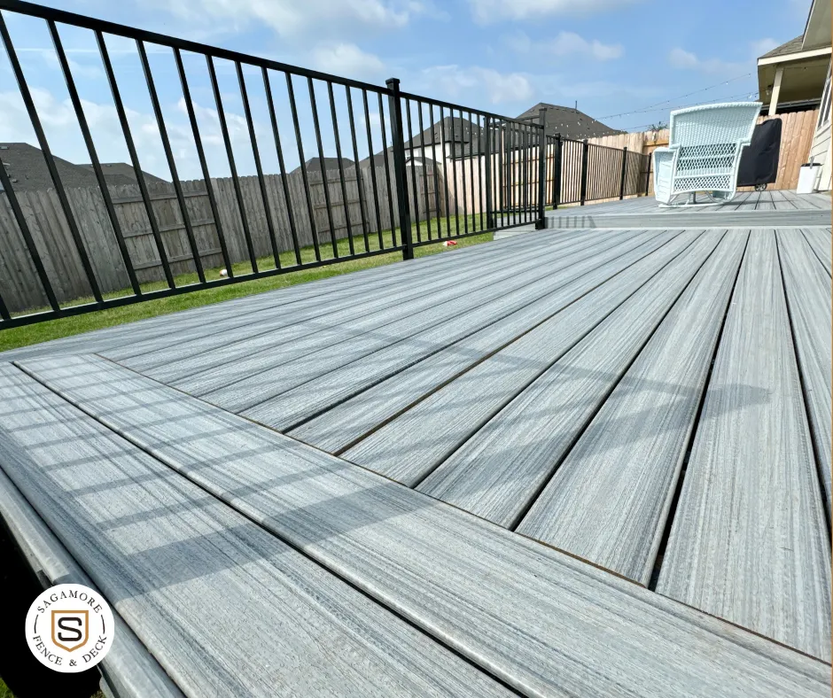 Gray deck with black iron railing in the backyard of an Austin, Texas home.