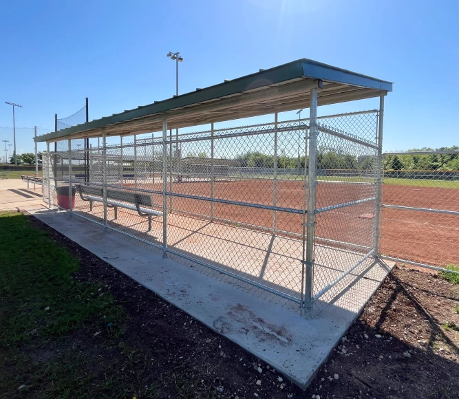 Dugout enclosed by a chain link fence.