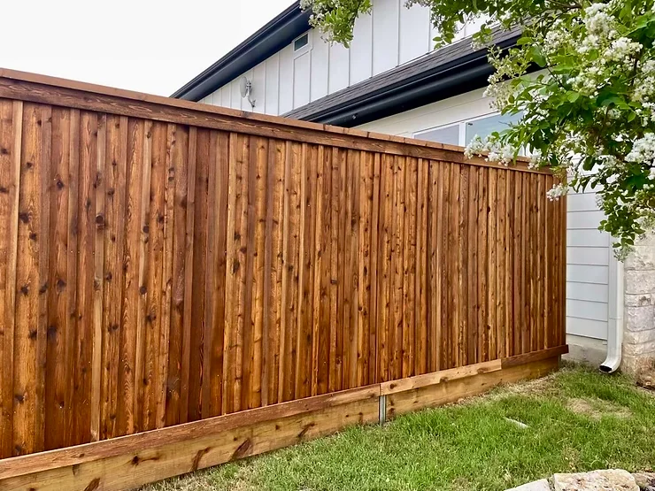 Dark stained wooden fence in the back yard of an Austin home.