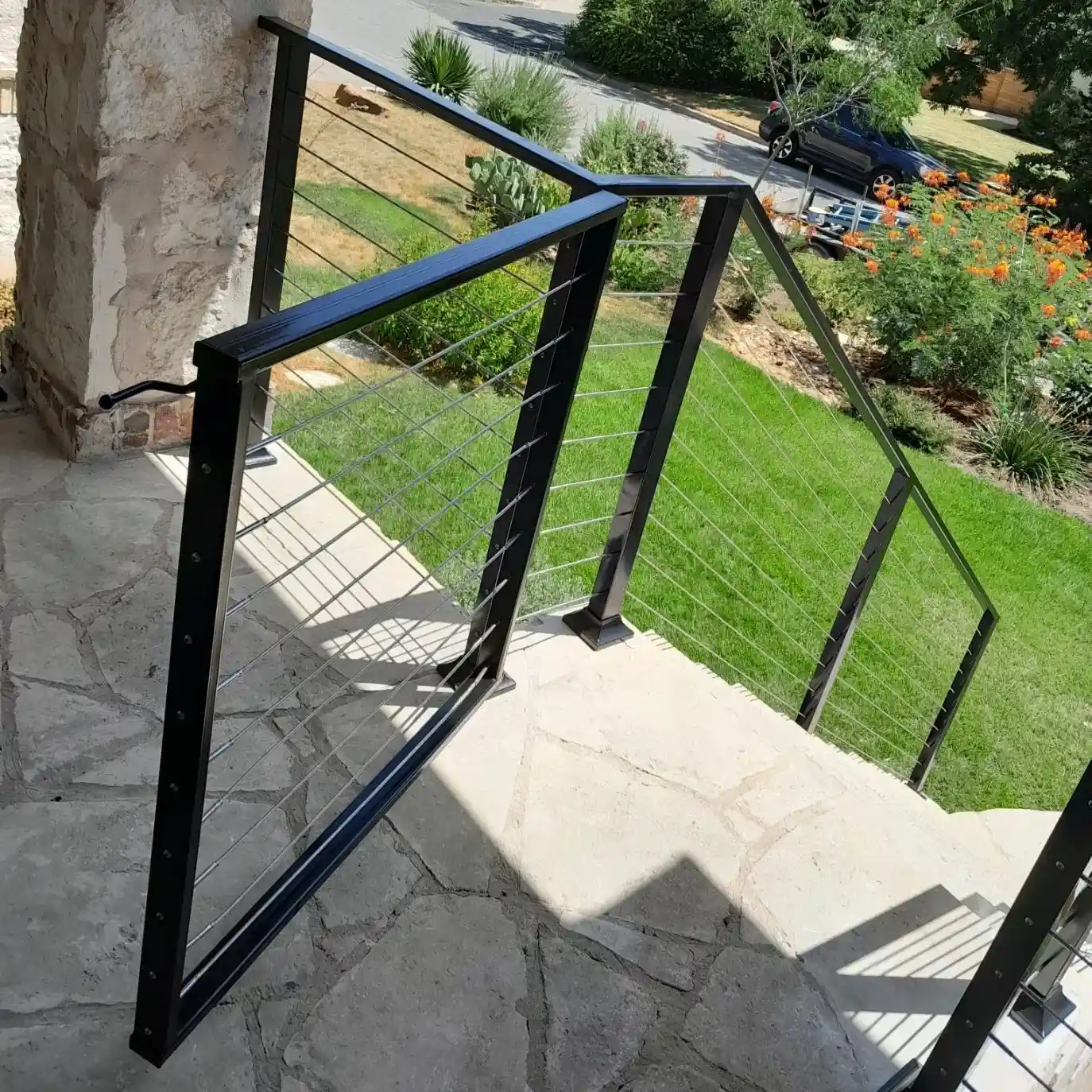 Custom stone patio with a black iron fence and gate.