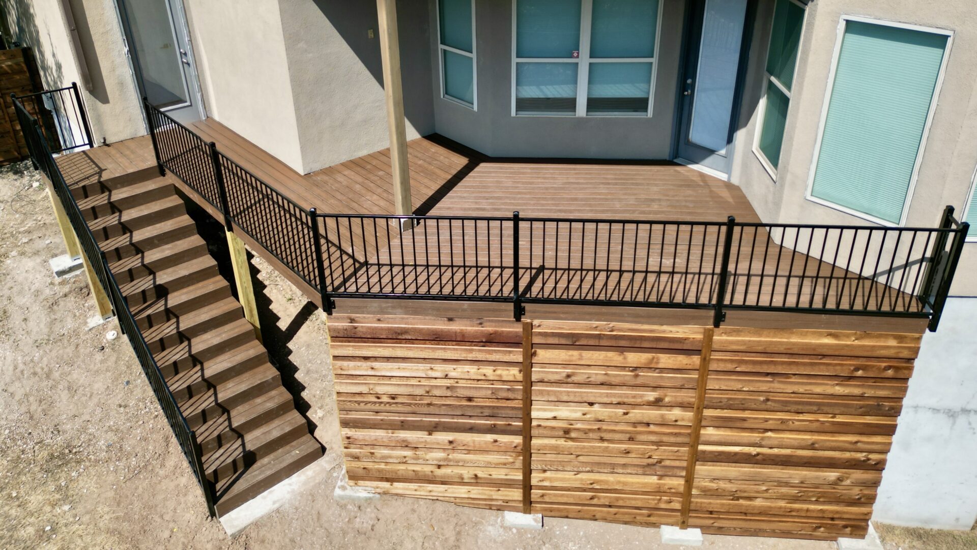 Brown Composite Decking with Western Red Cedar Skirting. Installed by Sagamore Fence & Deck, a Georgetown Fence Company