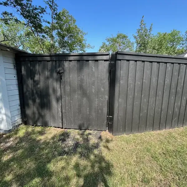 Black stained wood privacy fence with a matching walk gate