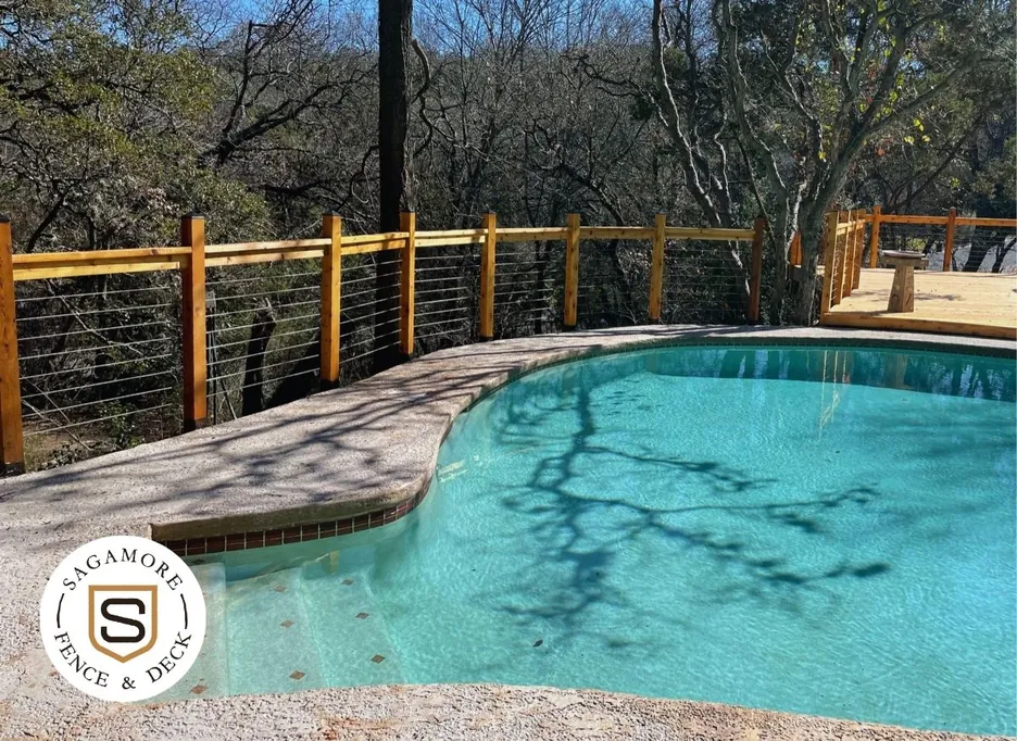 Cable railing with wood posts and top cap along a pool deck, built by Sagamore Fence & Deck