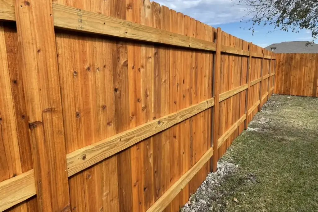 Cedar wood privacy fence running along a grassy side yard