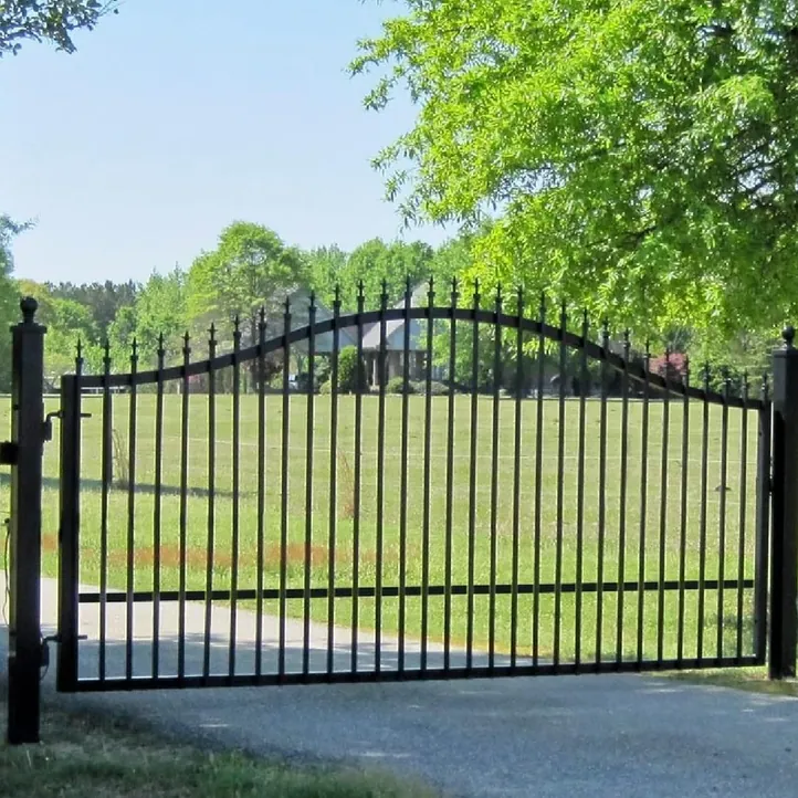Black arched iron drive gate with finials between steel posts, built by Sagamore Fence & Deck