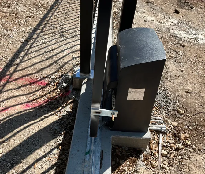 Close-up of a slide gate operator mounted beside the gate track