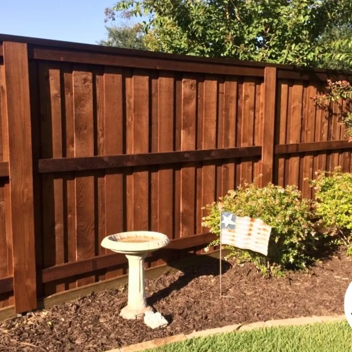 Stained board-on-board cedar privacy fence behind a garden bed