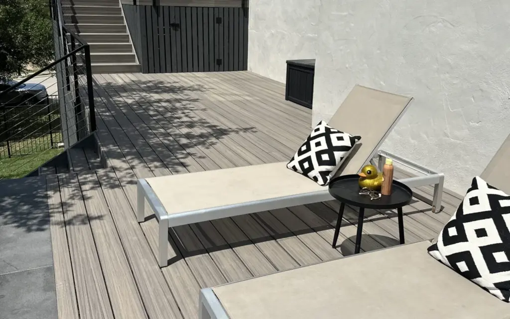 Gray Trex composite deck with lounge chairs and cable railing, built by Sagamore Fence & Deck, a TrexPro builder in Central Texas